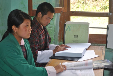 photo: a visually impaired student reading a braille book in the class